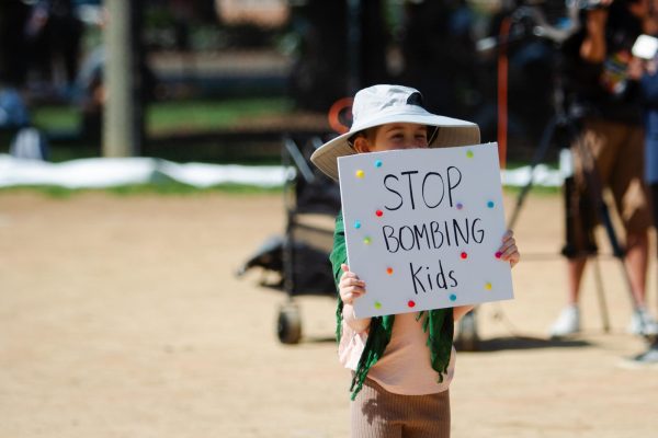 A child holds up a sign reading "stop bombing kids" during a protest on Monday, Aug. 19. Since Oct. 7, more than 10,000 children have been killed in Gaza, according to the Gaza Ministry of Health.