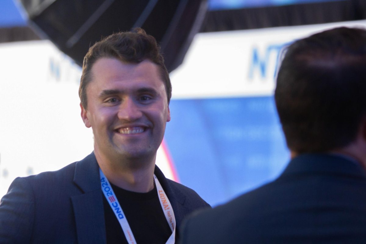 TurningPointUSA Executive Director Charlie Kirk talks with attendees at the 2024 Democratic National Convention in Chicago. A longtime critic of higher education for both political and economic reasons, Kirk published “The College Scam: How America’s Universities Are Bankrupting and Brainwashing Away the Future of America’s Youth” in 2022.