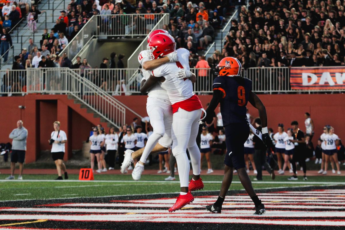 Wide receiver DeShaun Williams (1), a senior, celebrates with teammate Vincent Bern, a junior, after scoring a touchdown. Williams would rack up two touchdowns for the Redhawks by the end of the game, which was a 24-21 victory for Naperville Central.