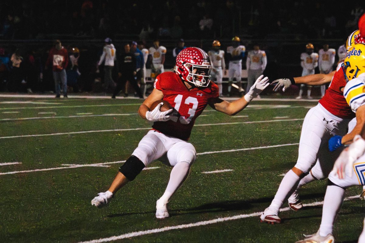 Senior Aiden Clark runs downfield as the Sandburg defense looks to stop his rush. The Redhawks won 22-8, clinching the Southwest Valley Red championship.