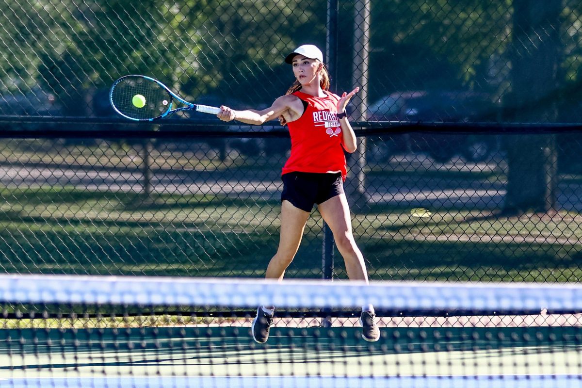 Senior Sophia Olaru smashes her racquet against a ball in a game against Neuqua Valley on Sept. 3. Olaru would claim her fourth consecutive DVC title on Oct. 12. (Photo Credit: Lifetouch)