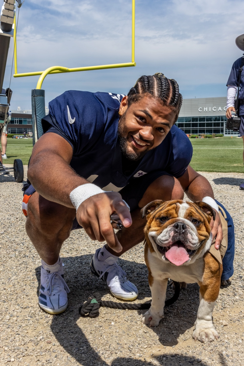 Chicago Bears wide receiver Rome Odunze poses with a dog on Aug. 8 at Halas Hall in  Lake Forest, Illinois. Odunze was selected by the Bears ninth overall in the 2024 NFL draft. (Photo Credit: Cpl. Alexander Devereux via DVIDS)