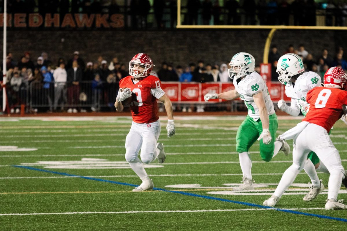 Senior Aiden Clark (13) looks for a first down as York's defense pursues him on Nov. 23. Naperville Central lost to the York Dukes in the IHSA State Series semifinal 15-20.