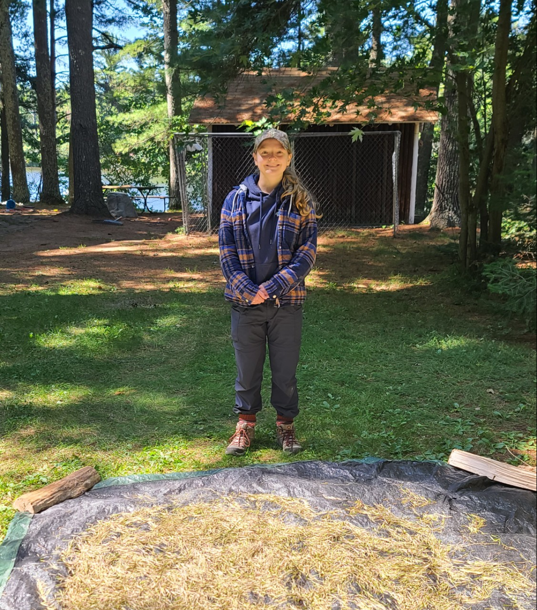 Estella Czech stands in front of the wild rice she and her father harvested as it dries on the tarp. (Photo courtesy of Estella Czech)