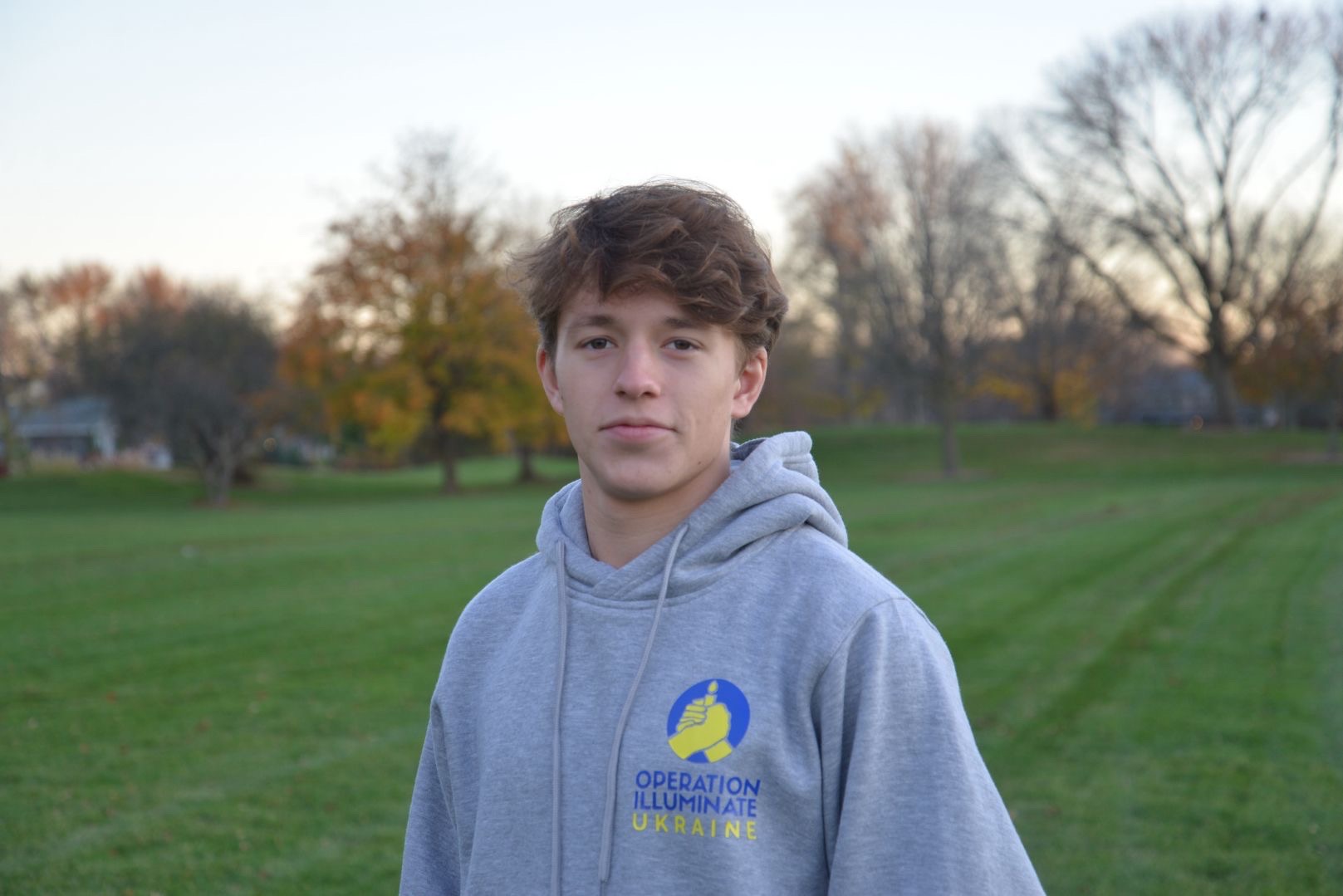 Central senior Andrew Lazovski poses for a photo in an Operation Illuminate Ukraine sweatshirt. Lazovski traveled to Ukraine as part of the initiative, distributing 17 tons of humanitarian aid. (Photo courtesy of Andrew Lazovski)