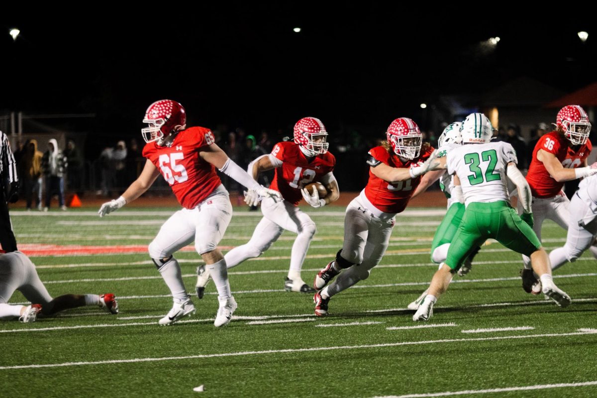 Senior Garrett Nichols runs the ball downfield in a game against York on Nov. 23. Naperville Central's football program was named the 42nd best in Illinois history by the IHSA.