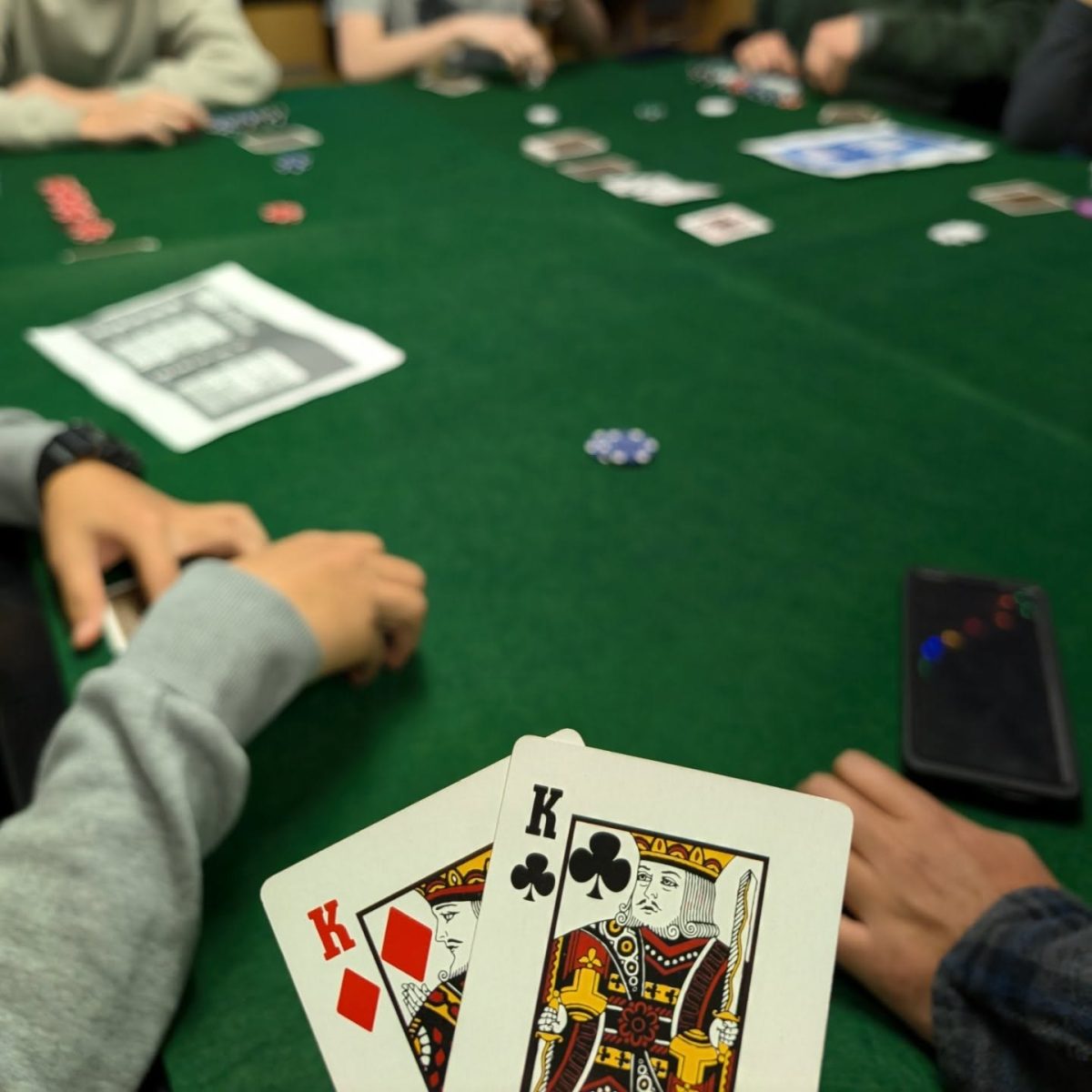 A player holds a pair of pocket kings during a game of poker on Nov. 21. A pair of pocket kings is one of the strongest hands in Poker. The game was part of a meeting of All-in Club which offers playing and learning opportunities to students in Room 331 from 3:20-4:20 p.m. every Thursday. (Photo Credit: @nchs_all_in via Instagram)