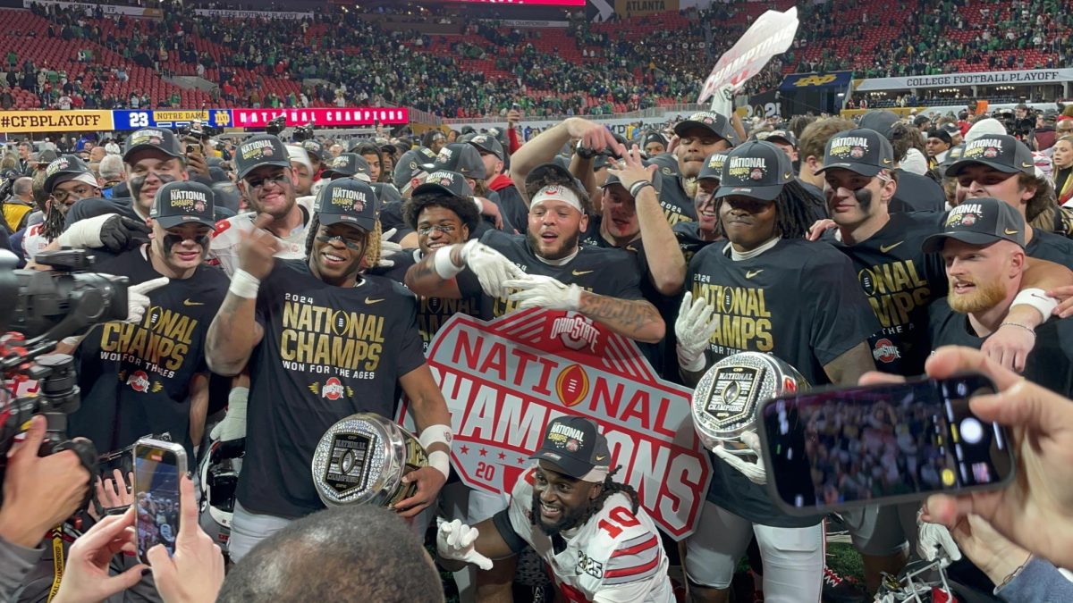 Members of the Ohio State Buckeyes celebrate their victory in the College Football Playoff National Championship on the field of Mercedes-Benz Stadium in Atlanta on Jan. 20. The new 12-team playoff system shows promise. (Photo credit: Bobak Ha'Eri via Wikimedia Commons)