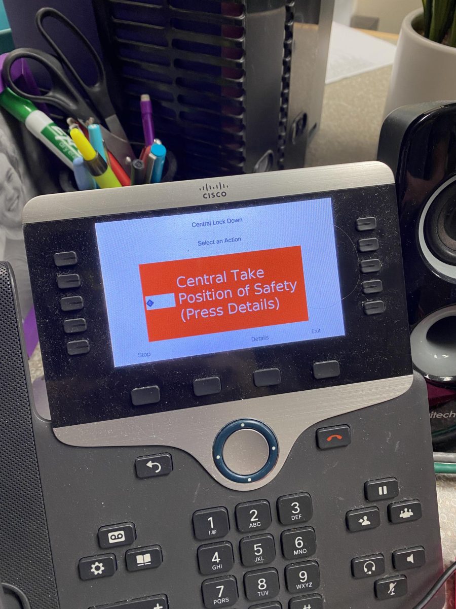 A phone in Room 218A displays an emergency alert message on Feb. 25. An accidental lockdown was triggered at Naperville Central due to the accidental activation of a staff ID card. 